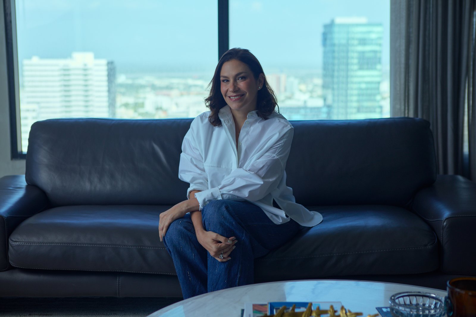 Stefy Dager sentada en su sala, con Barranquilla al fondo